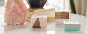 A display of candle holders, salt lamp,, and planters on a table