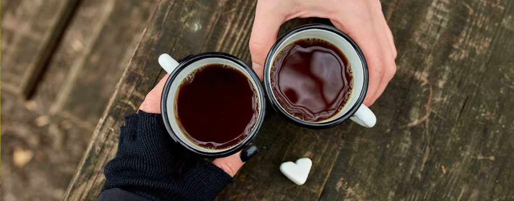 A couple of hands holding coffee mugs