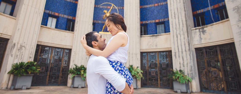 A man holding up a woman with a big smile, celebraing a long distance relationship.