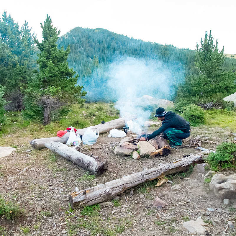 A hiker building a campfire.