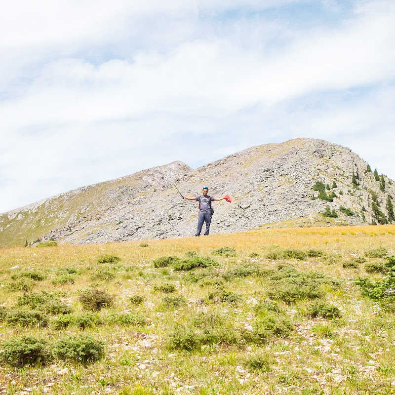 A hiker waving at the summit.