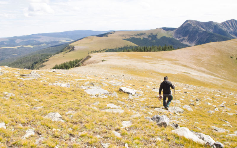 A man walking on a train in the mountains.