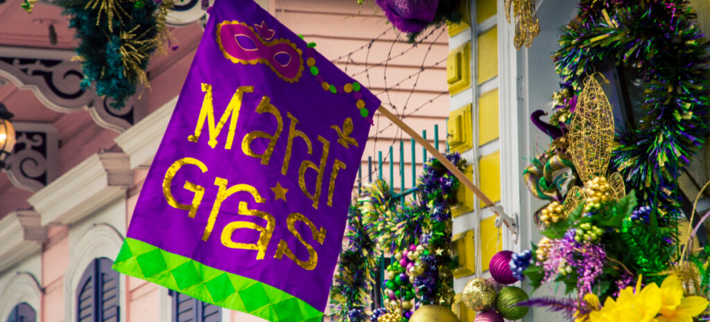 Mardi Gras flag hung on a brick wall.