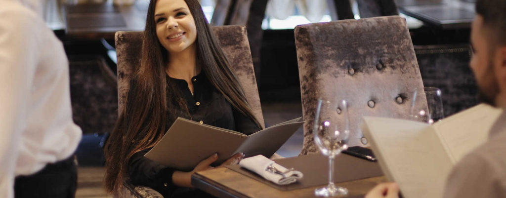 A woman ordering wine at a restaurant.