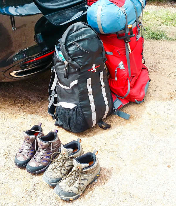 Two hiking bags and two hiking boots.