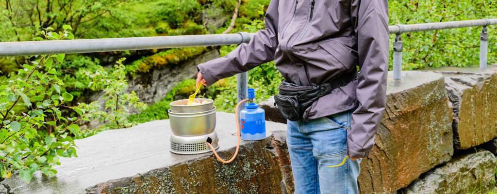 A hiker cooking a meal.