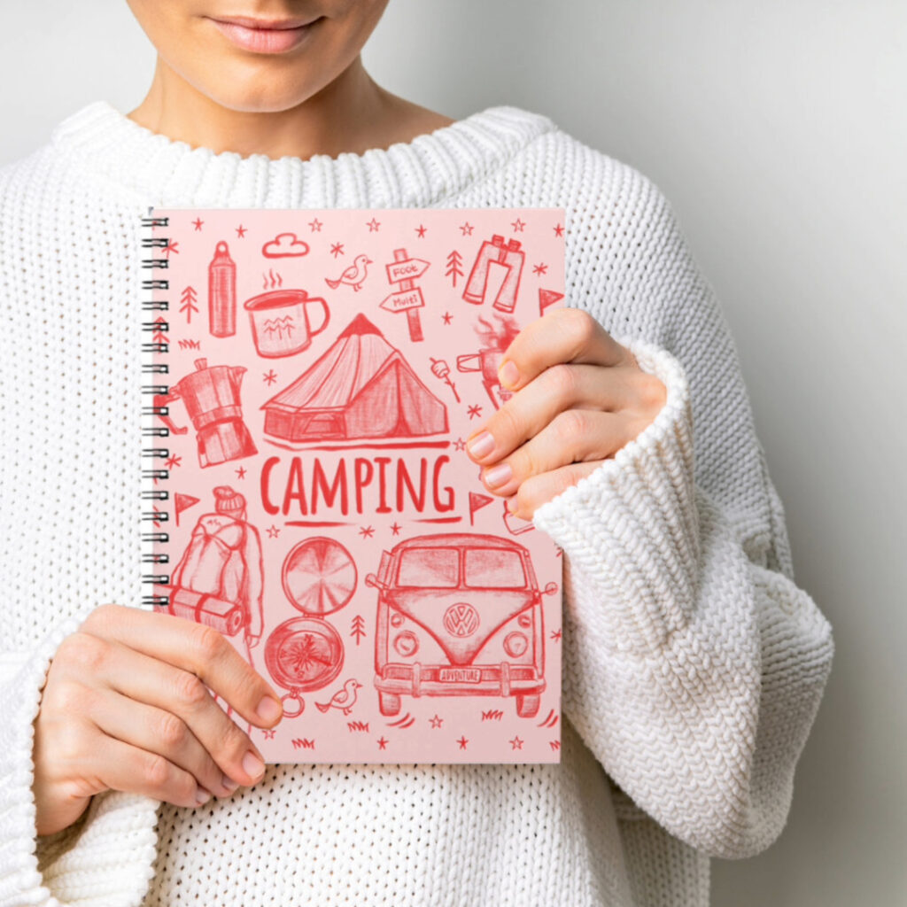 a person in white sweater holding a camping journal book.