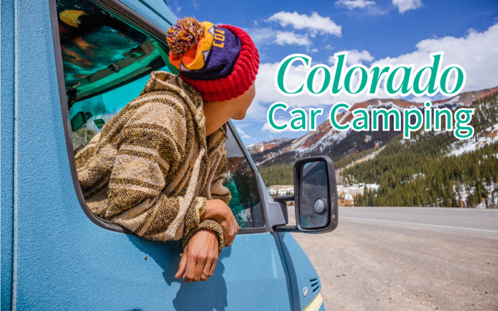 A person wearing rainbow colored winter hat popping out of car window and looking at snowed mountains.