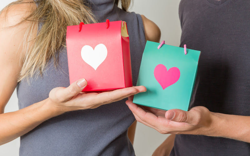 A couple holding small gift bags