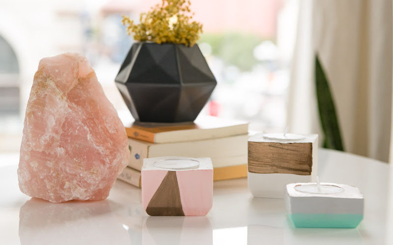 A display of candle holders, salt lamp,, and planters on a table