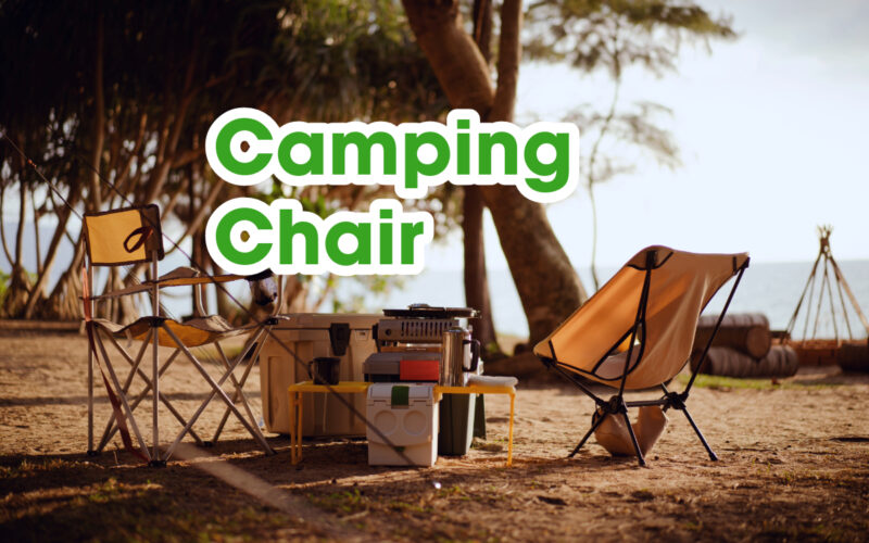 Camping chairs and cooking tools set up on a camp ground.