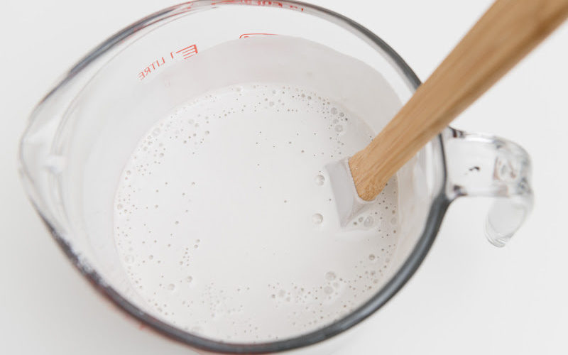 Stirring white wax with a wooden spoon