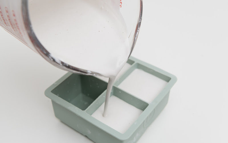 Pouring white wax into a plastic container