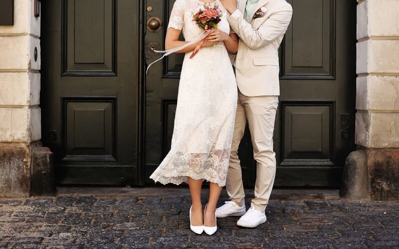 A bride and groom in front of a courthouse door.