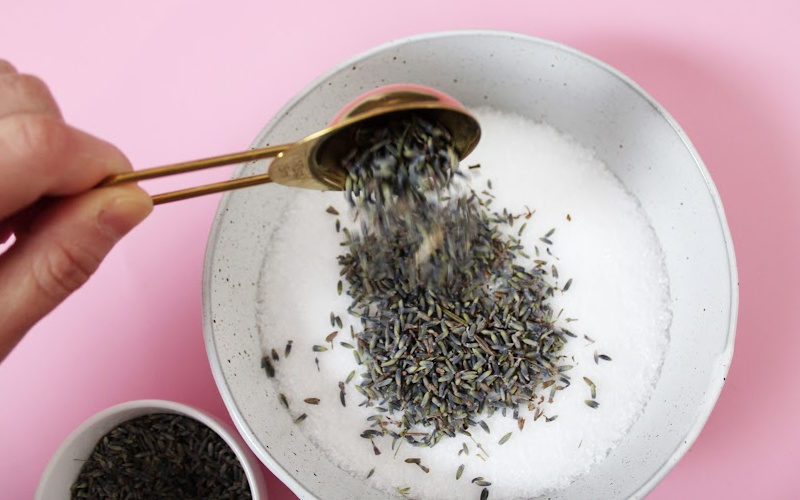 Adding lavender buds to a bowl of Epsom salt