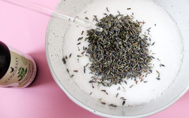 Adding essential oil to a bowl of lavender foot soak