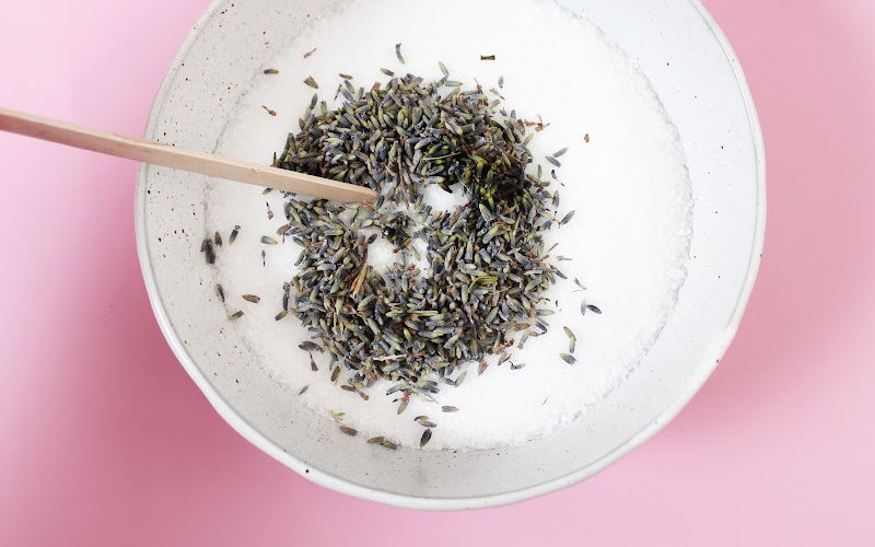 Stirring lavender buds with Epsom salt in a bowl