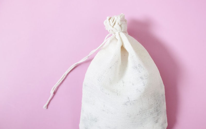 A small burlap bag on pink background