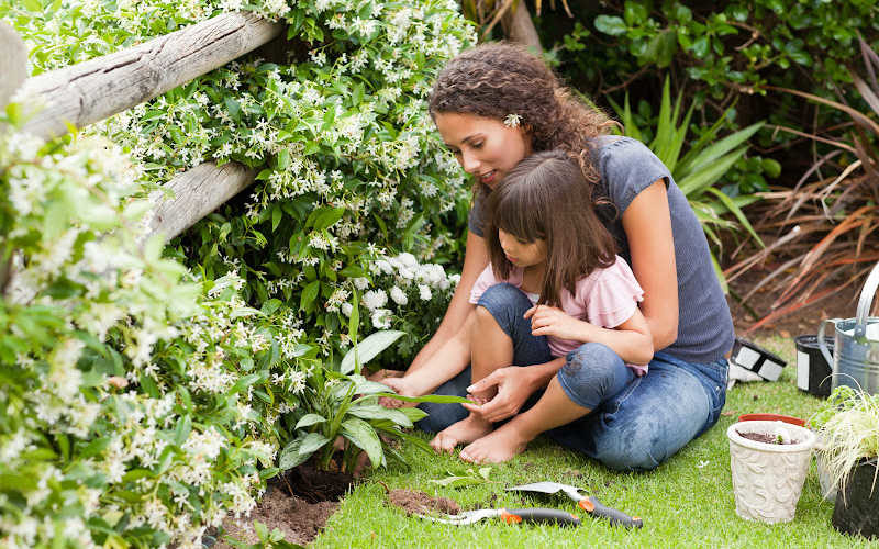 Mom and daughter sitting on the garden