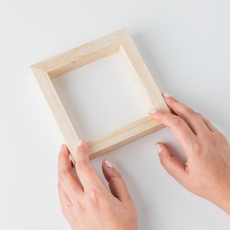 Someone holding a small wood frame