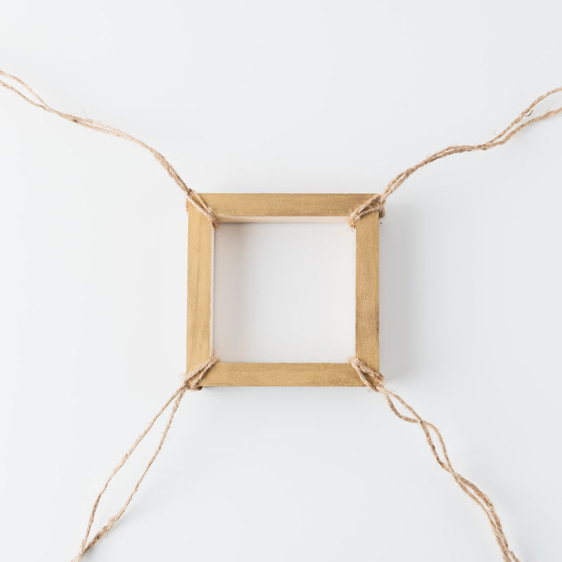 A small wooden frame with twine connected