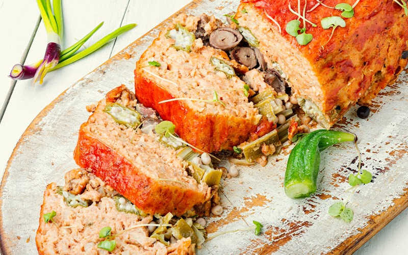 Sliced meatloaf with green peppers.