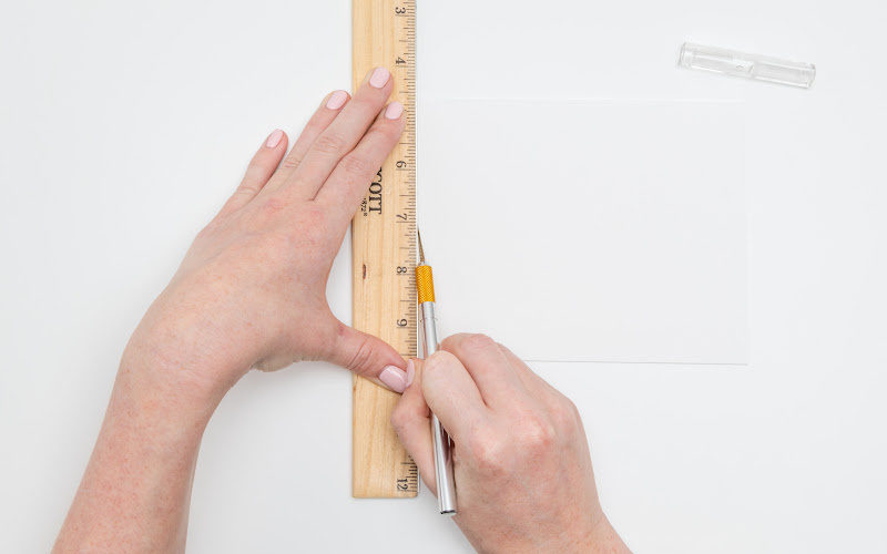 Cutting through a paper using a, exacto knife