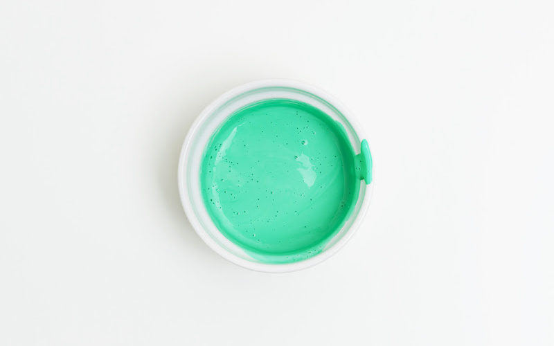 A white plate filled with bright green paint