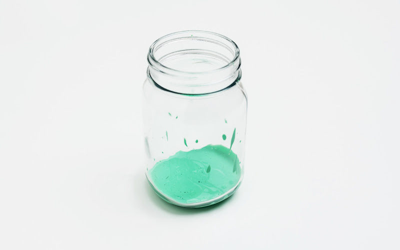 A mason jar filled with bright green paint