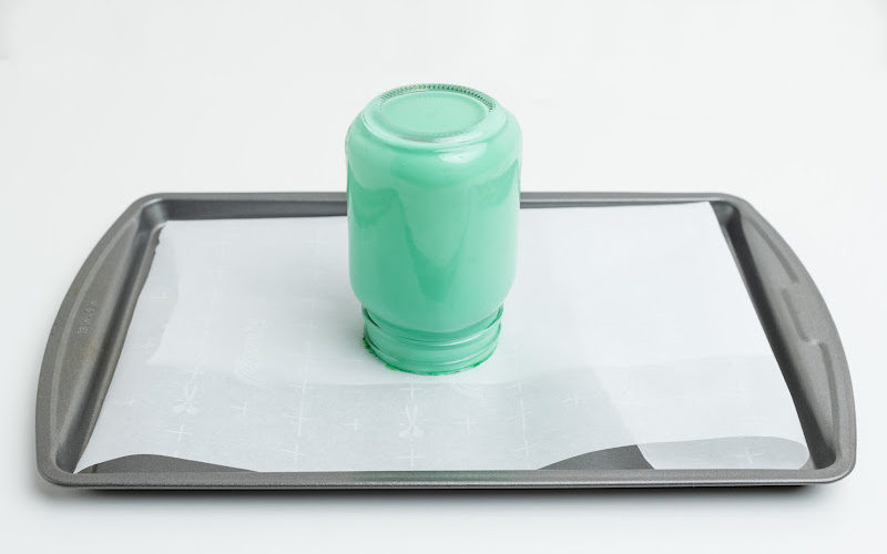 Green tinted mason jar placed on top of baking sheet