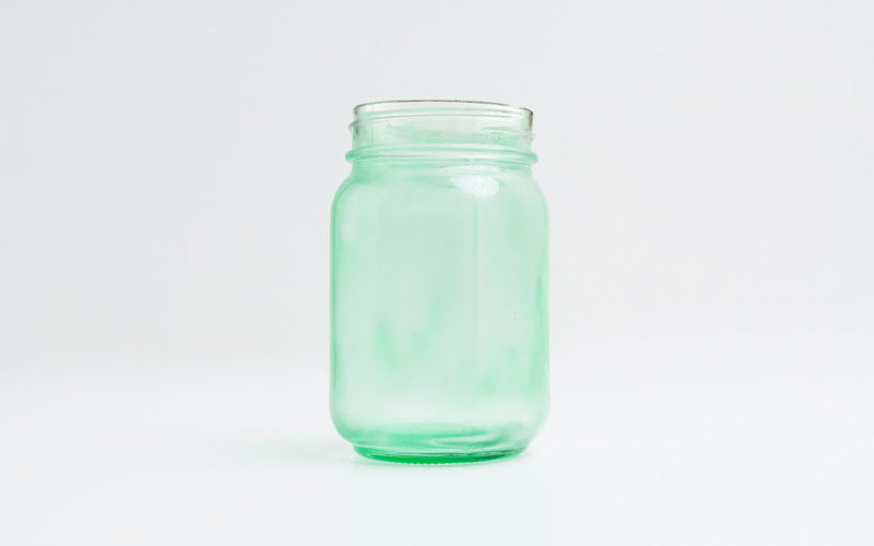 A glass of green tinted mason jar