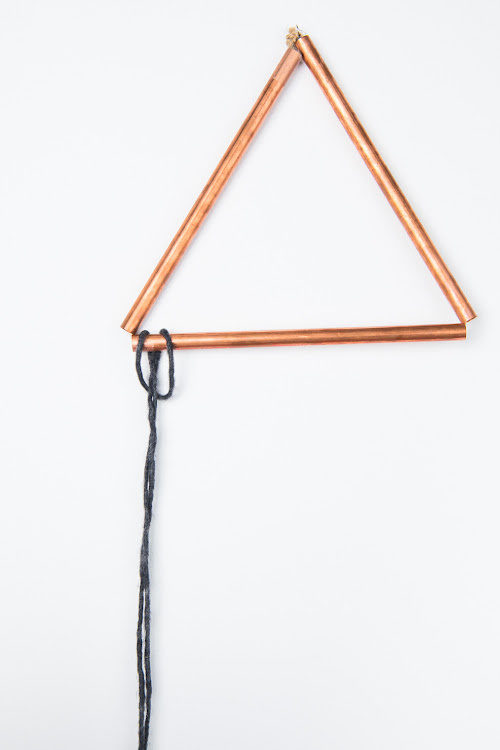 A string of yarn tied on a triangle metal rod